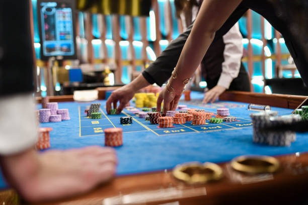 Live blackjack dealer at professional studio with multiple camera angles showing table layout and cards